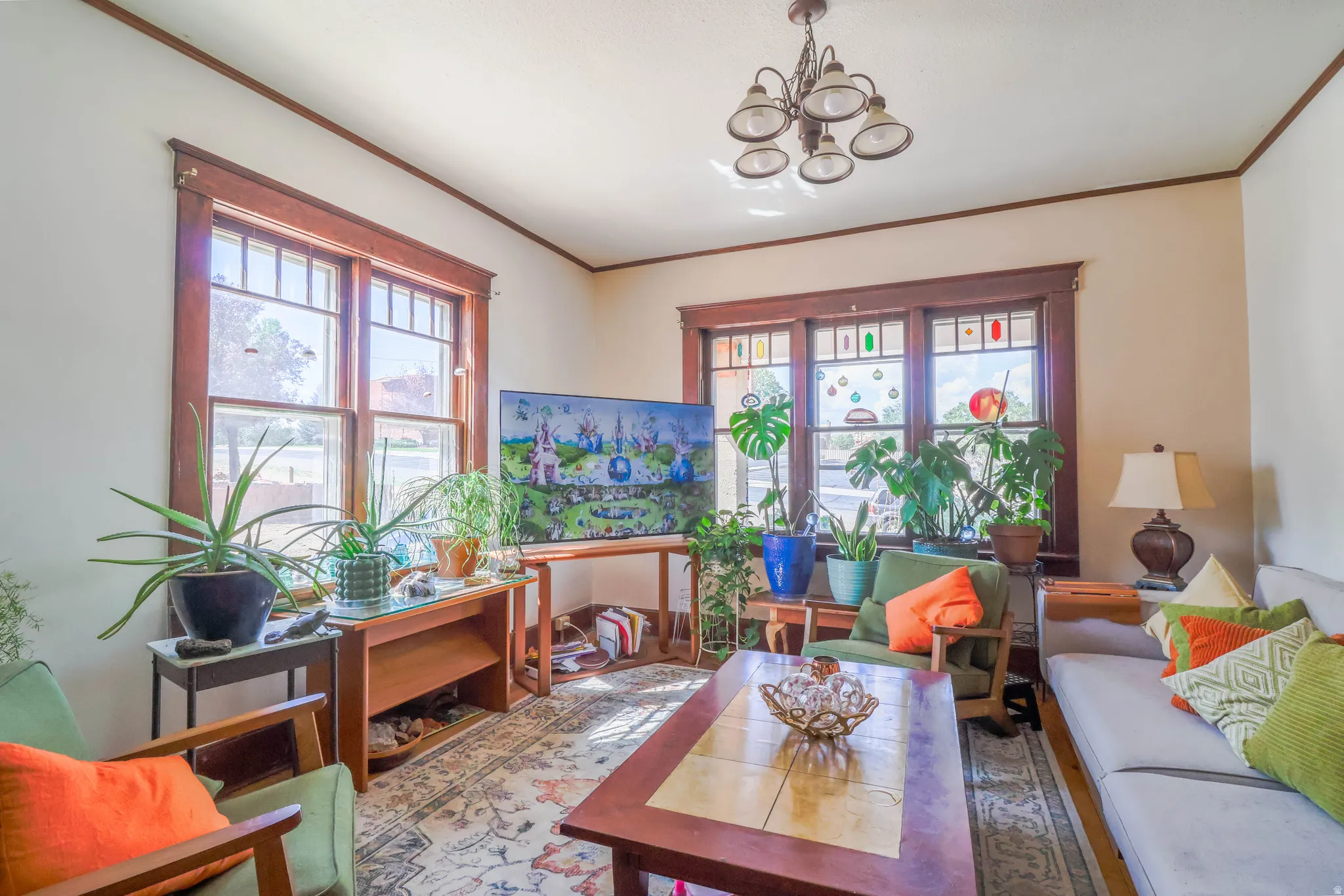 Living area featuring a multi-light chandelier, wood-trimmed windows, and light-toned walls