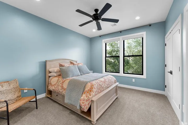 Recessed lighting, ceiling fan, double pane windows, white trim, and light gray carpeting
