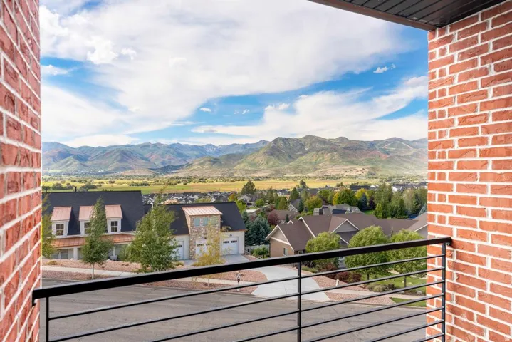 Exterior brick wall, black horizontal railing, and distant mountain range