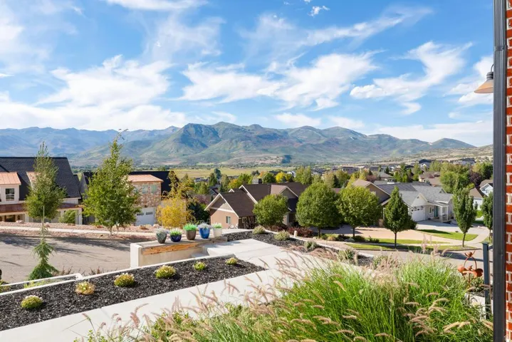 Paved concrete pathway with integrated landscaping beds and a stone retaining wall