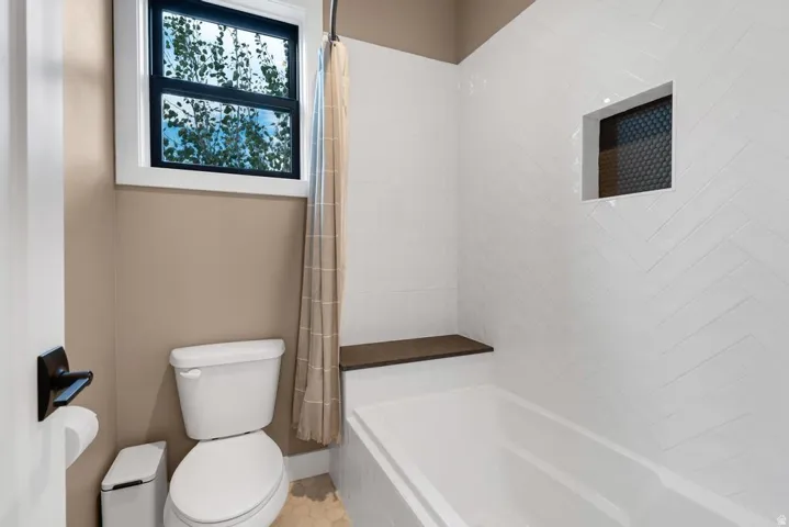 White subway tile shower surround in a herringbone pattern with a built-in niche