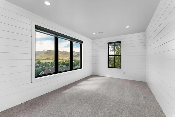 White shiplap walls with recessed lighting and gray carpeting