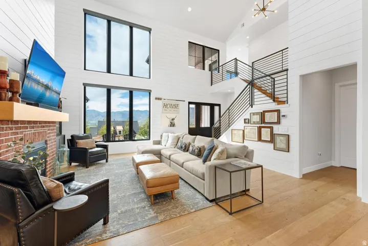 Two-story living area with high ceilings, shiplap wall finishes, and light wood-finish flooring