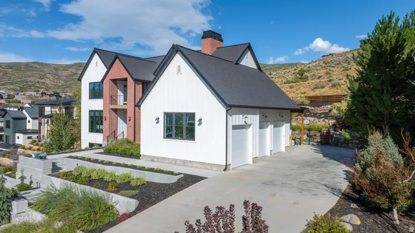 Modern farmhouse-style residence with white board-and-batten siding and brick accents