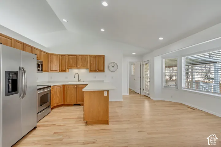 Vaulted ceiling, recessed lighting, wood-finish flooring, stainless steel appliances, and a bay window