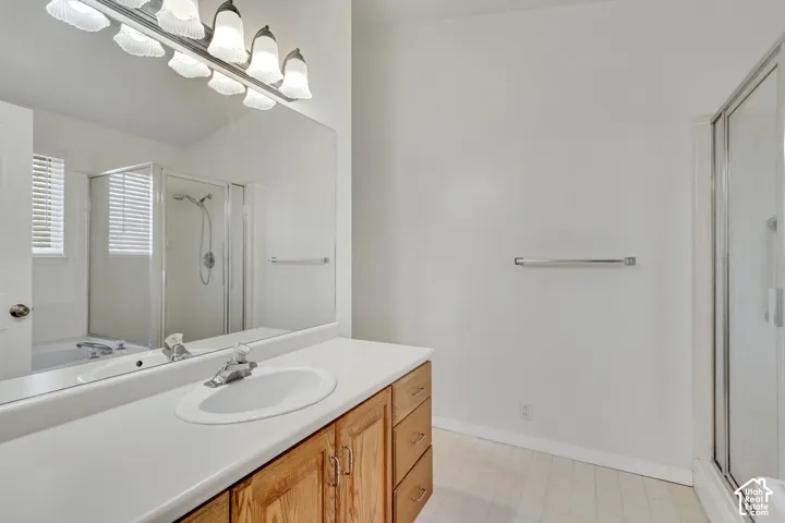 Bathroom with a wood-finish vanity, integrated sink, and an expansive mirror