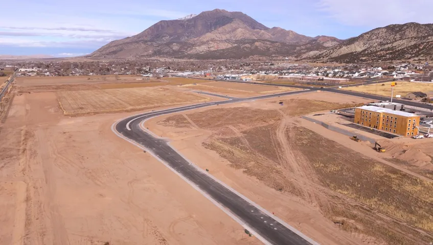 Expansive land parcel with paved access roads and mountain backdrop