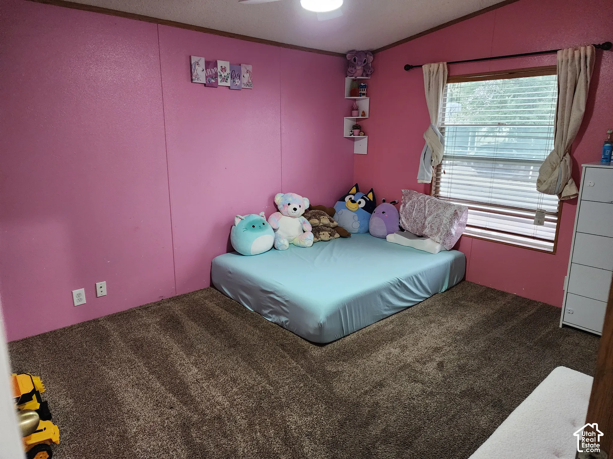 Room featuring wall-to-wall carpeting, corner-mounted floating shelving, and a window with horizontal blinds