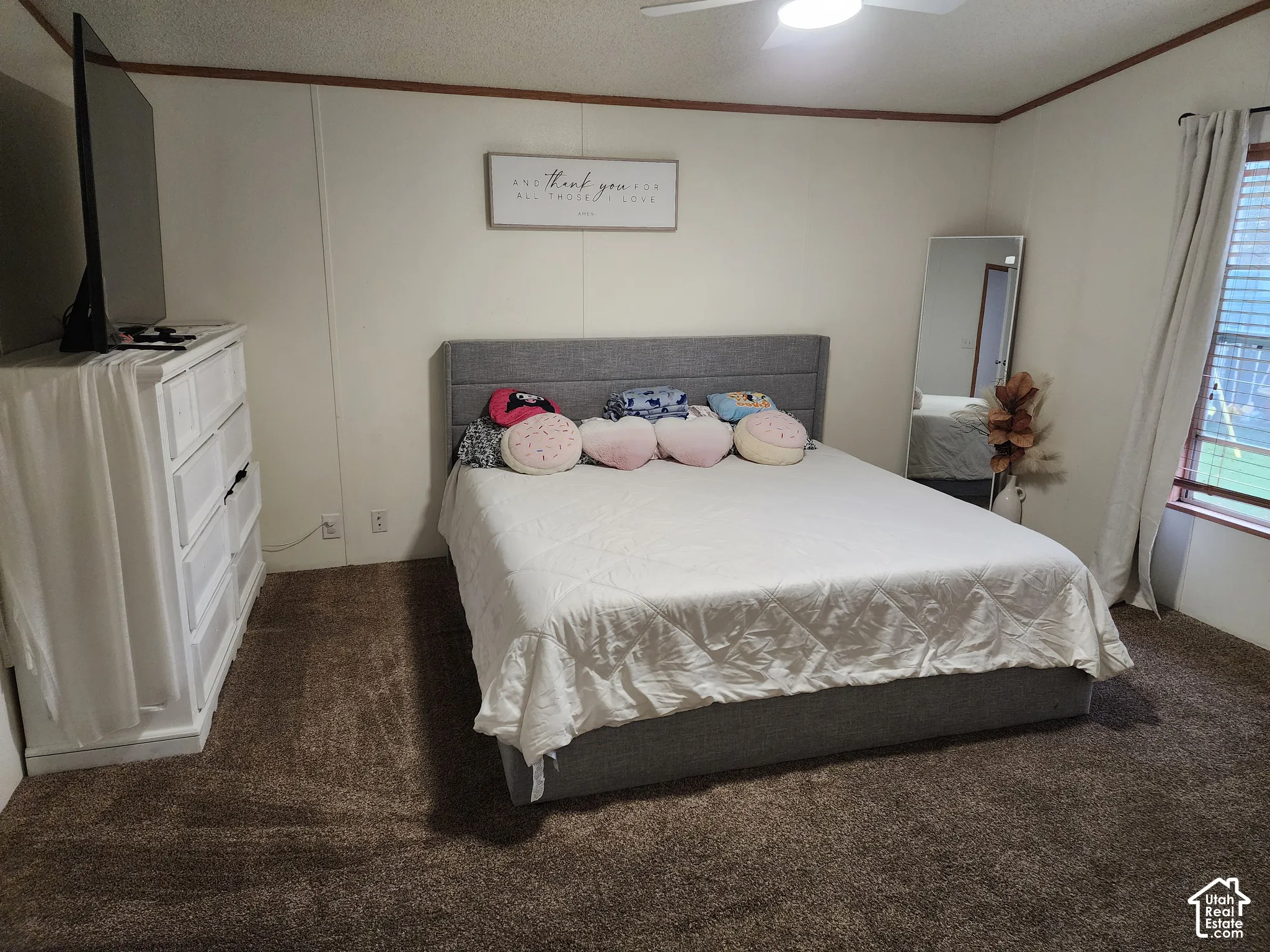 Bedroom featuring neutral wall paneling, ceiling-mounted light fixture with fan, and carpeted flooring
