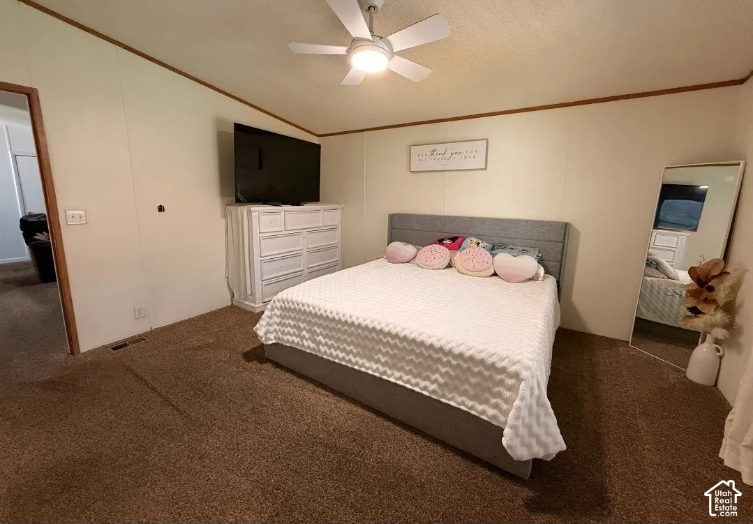 Carpeted flooring, white walls with wood trim, and a ceiling fan with integrated lighting