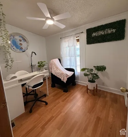 Wood-finish flooring, white walls, and a ceiling fan with integrated lighting