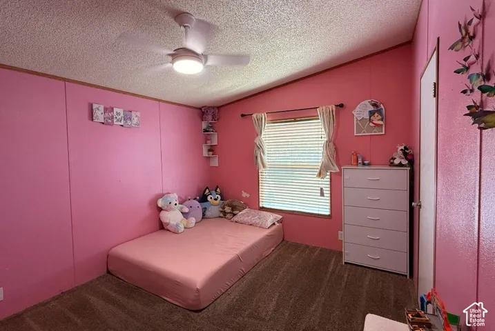 Room featuring a sloped ceiling, ceiling fan with integrated lighting, and carpet flooring