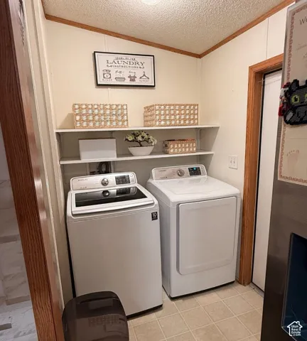 Laundry area with two white appliances, light-colored tile flooring, and white wall shelving