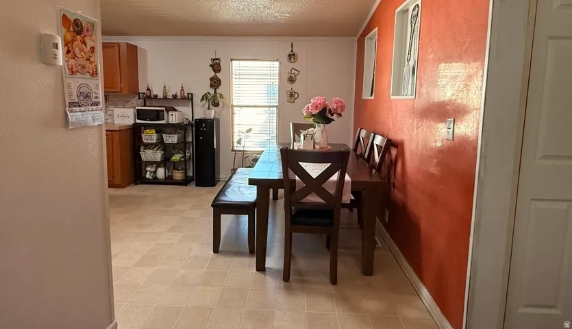 Dining area featuring a wood dining table, wood-finish chairs, and a window with blinds
