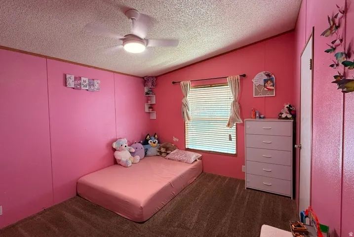 Room featuring a sloped ceiling, ceiling fan with integrated lighting, and carpet flooring