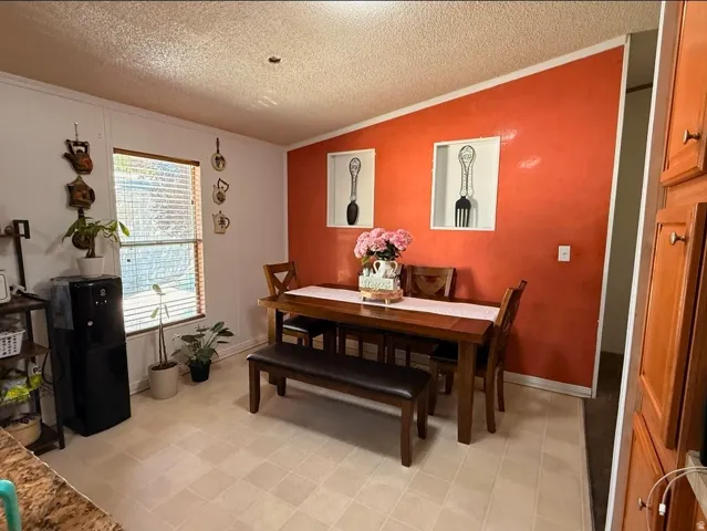 Recessed wall niches, light-toned flooring, white baseboards, and a window with blinds