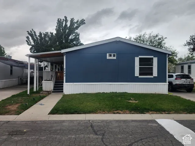 Exterior profile featuring blue siding, white trim, a covered front porch, and concrete walkway