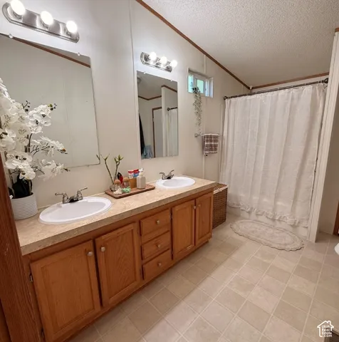 Dual vanity with white ceramic sinks, wood-finish cabinetry, and laminate countertops