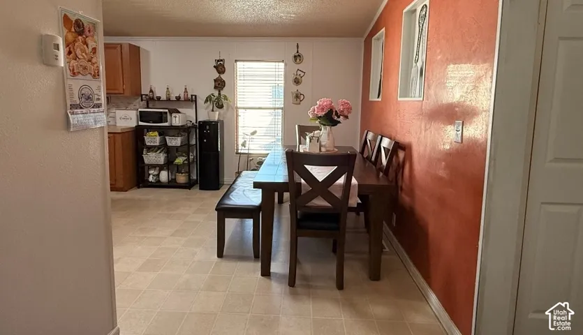 Dining area featuring a wood dining table, wood-finish chairs, and a window with blinds