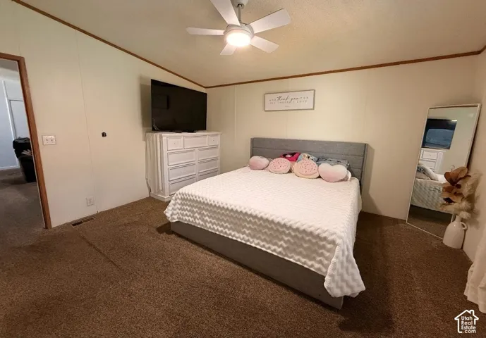 Carpeted flooring, white walls with wood trim, and a ceiling fan with integrated lighting