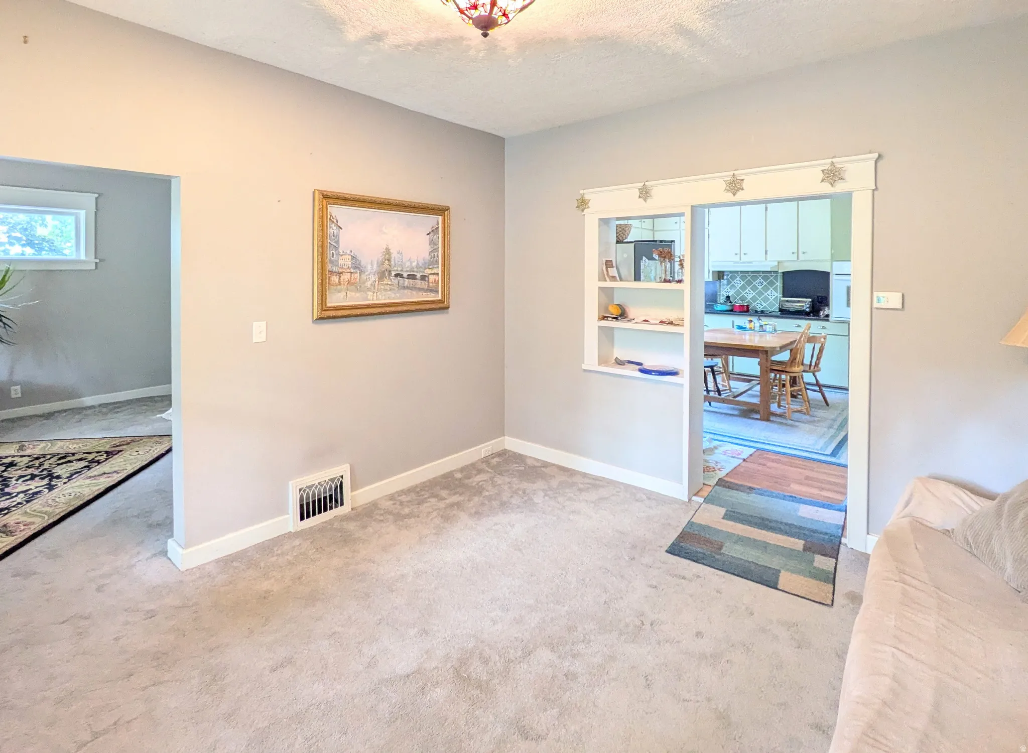 Carpeted room with light gray walls, white trim, and a built-in shelving unit