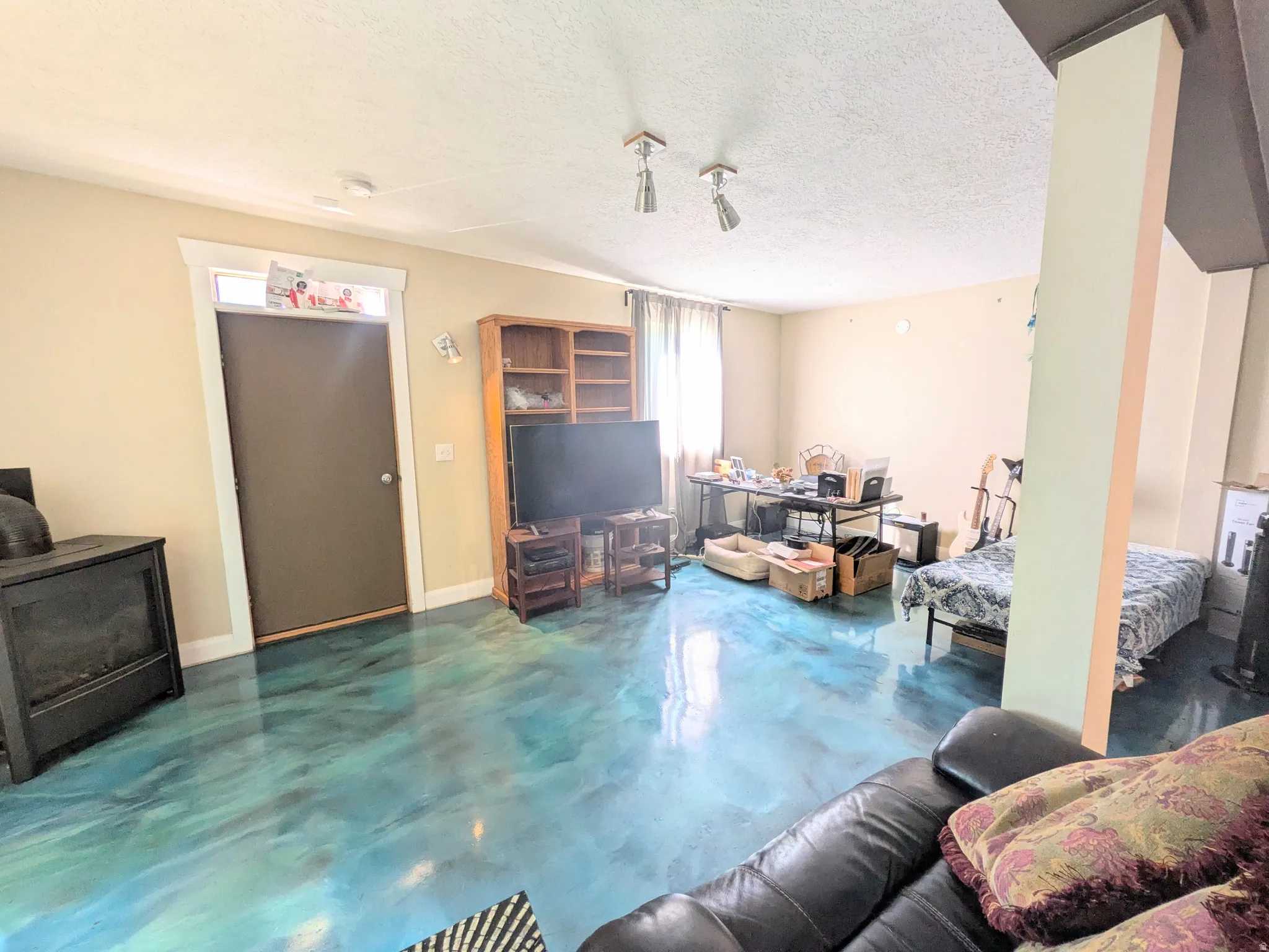 Unique epoxy flooring, track lighting, and a painted accent column