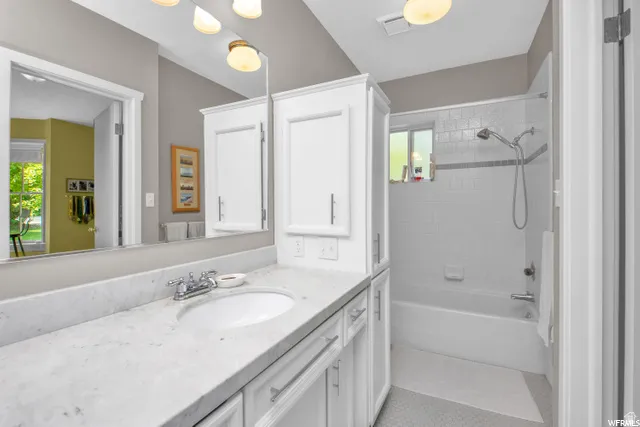 Built-in vanity with a white oval sink, chrome faucet, and spacious countertop