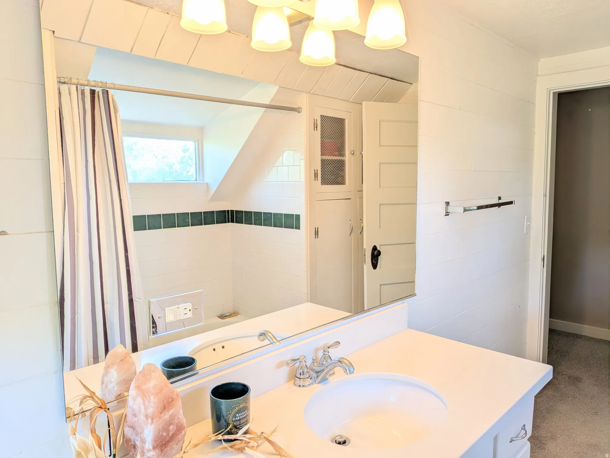 White vanity with integrated sink, chrome faucet, and expansive wall-mounted mirror