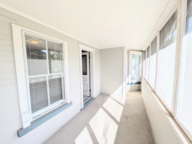 Enclosed porch with beadboard ceiling, wood-finish flooring, and natural light
