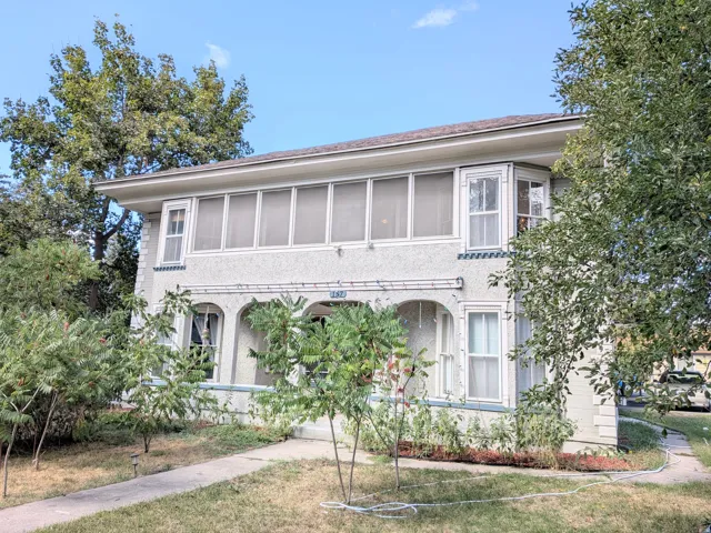 Stucco exterior with an enclosed porch, archway details, and a bay window