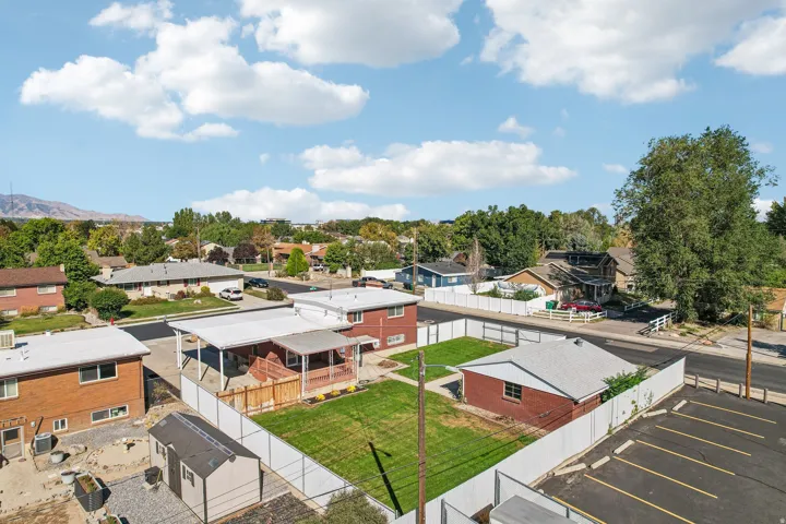 Brick exterior, white fencing, manicured lawn, detached garage, paved parking area