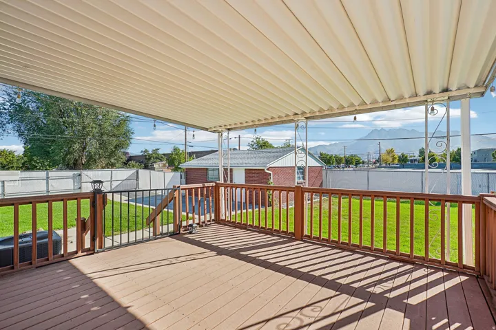 Covered deck with composite decking, wood railing, and metal support posts