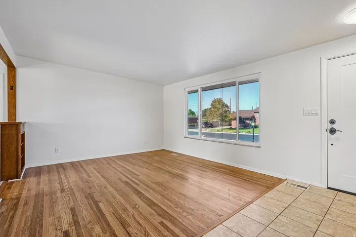 Hardwood flooring, white walls, and a large window