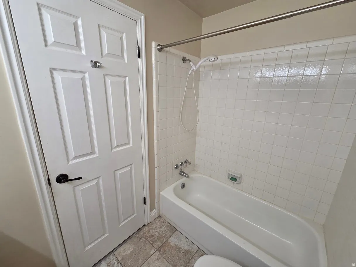 Main Bathroom tub and shower combination with white tile surround