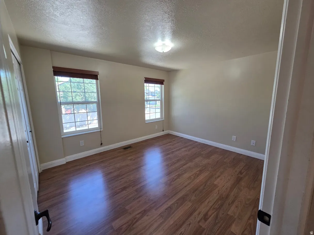 Primary Bedroom with Wood-finish flooring, dual windows, and ceiling-mounted lighting