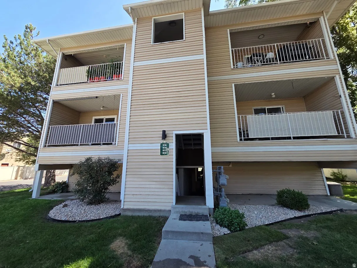 Cream-colored vinyl siding exterior with multiple covered balconies