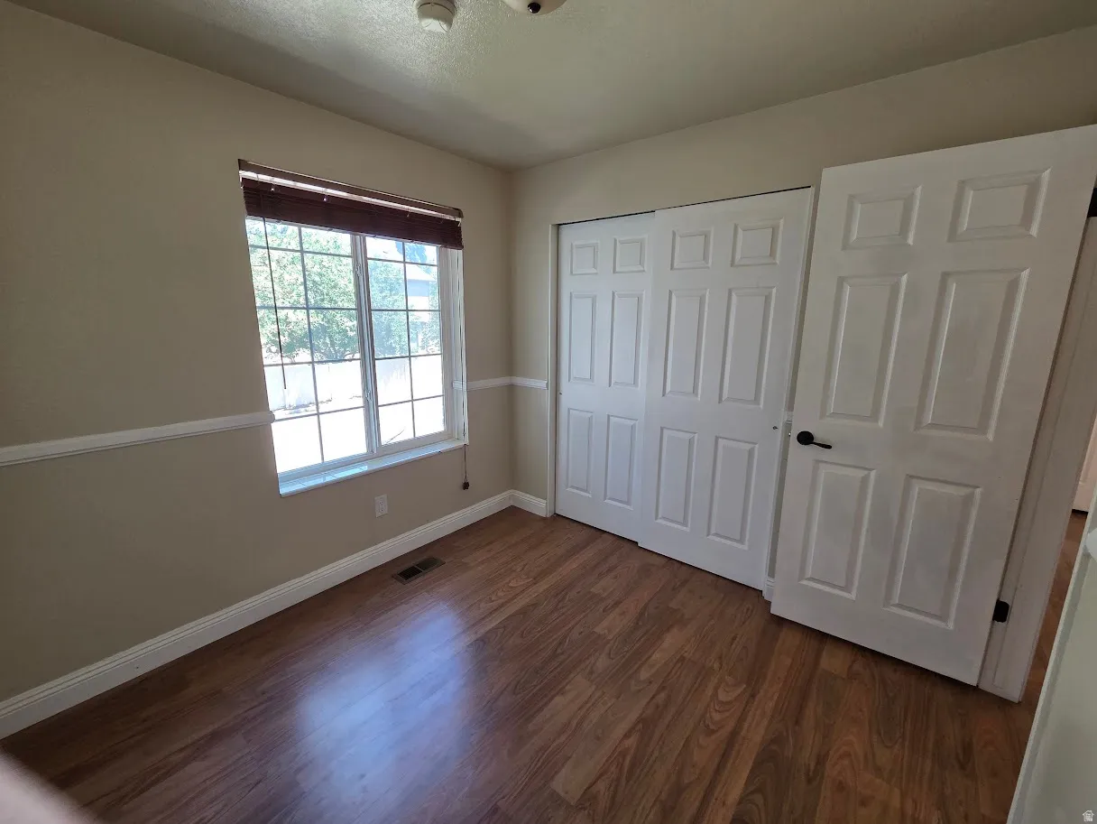 2nd Bedroom with wood-finish flooring with white baseboards