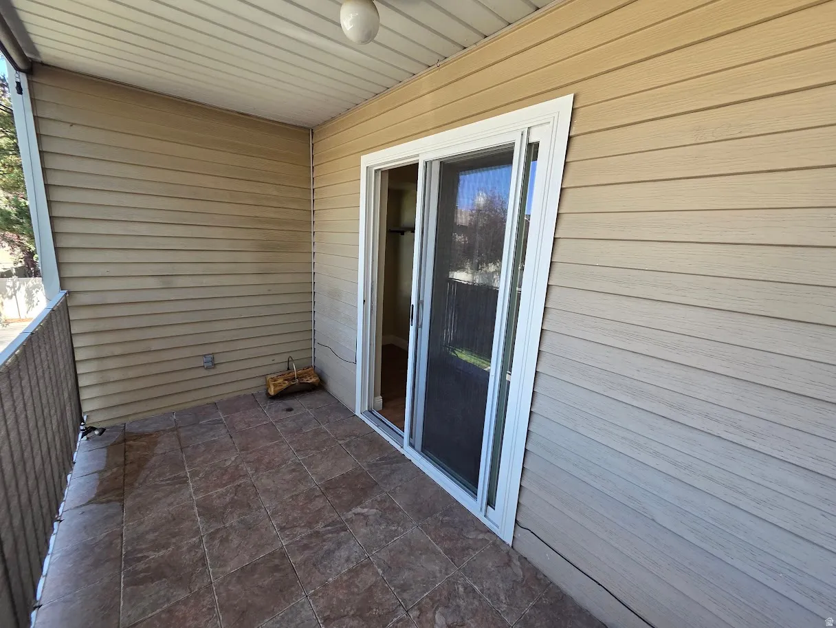 Outdoor patio featuring tiled flooring, sliding glass door, and a protective railing