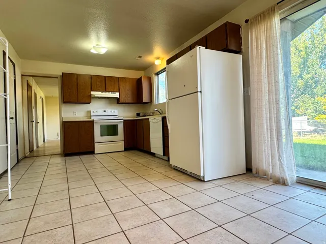 Unit 2 Kitchen.  Doorway on the left provides access to the other unit.  Doors to the left access that half bath off of each kitchen, and the doors to each of the water heaters.