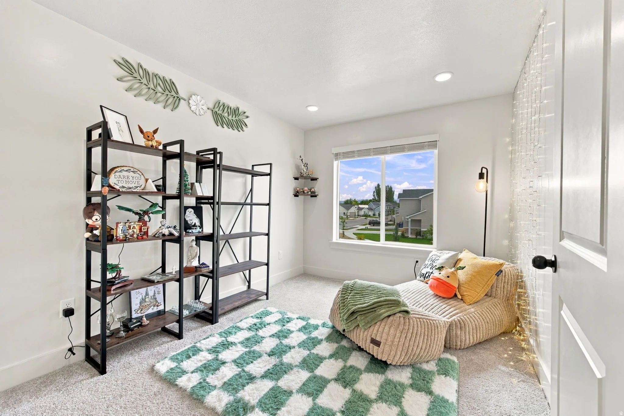 Recessed ceiling lighting, white interior walls, window with white trim, wall-to-wall carpeting, and a built-in shelving unit