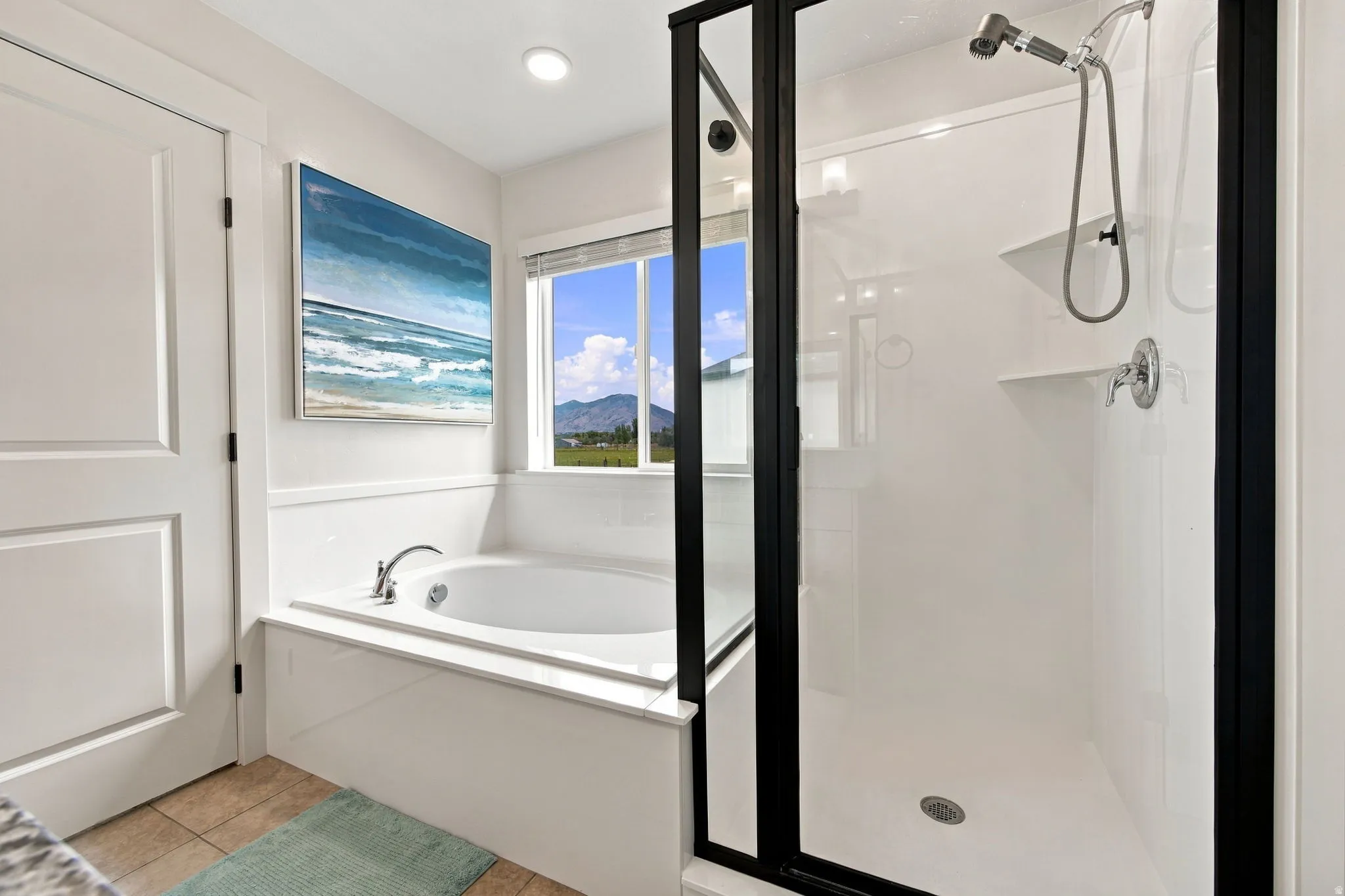 Built-in soaking tub with chrome fixtures, enclosed shower with matte black frame, tile flooring, and recessed lighting