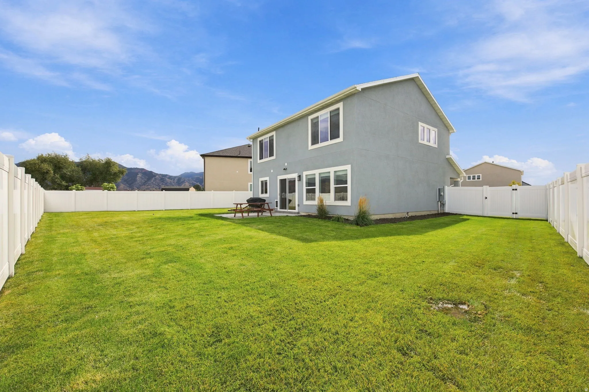 Expansive green lawn with a full vinyl fence enclosure