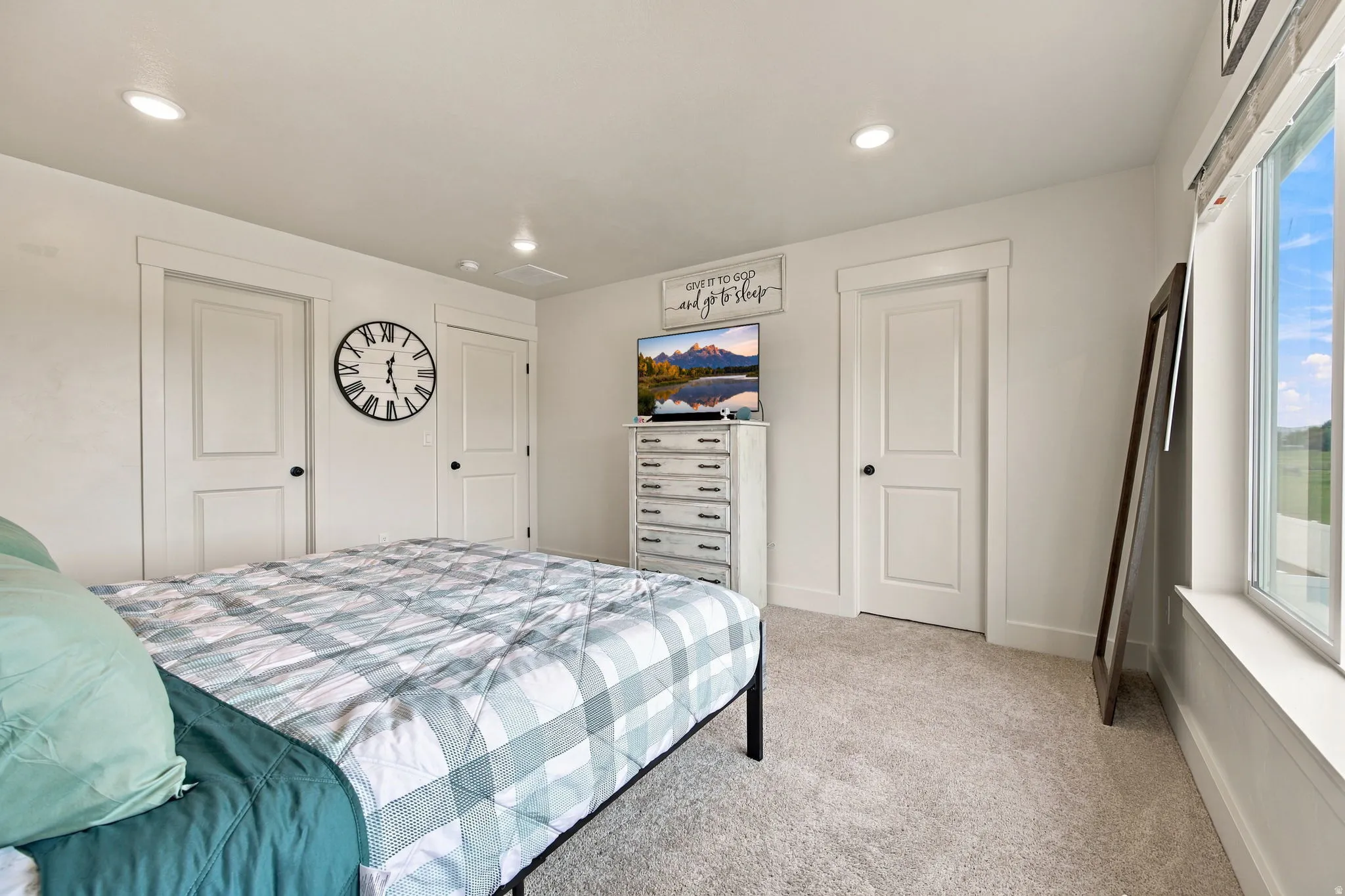 Plush carpeting, recessed lighting, and white trim accents