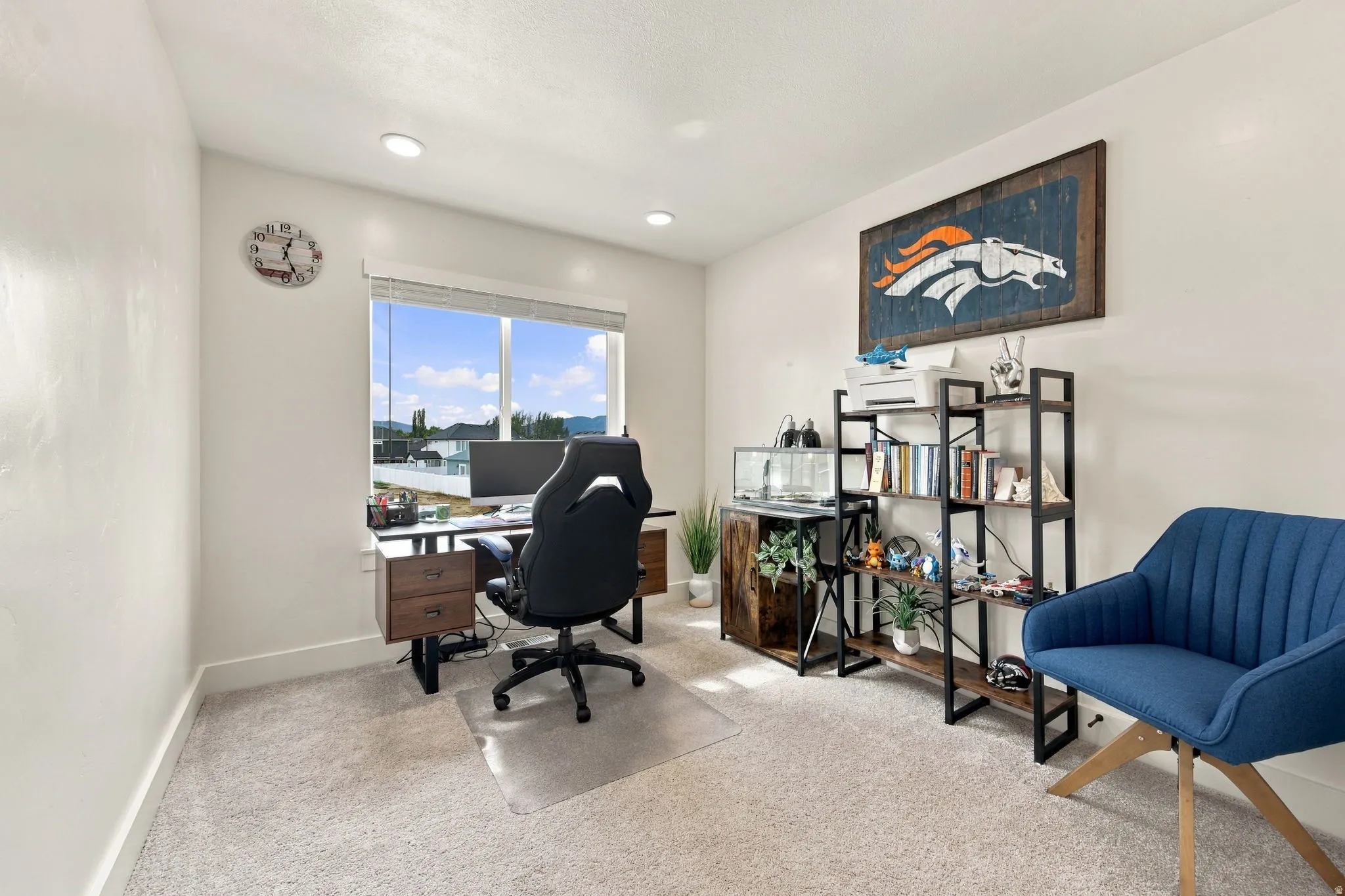 Recessed lighting, large window, and light-toned carpeting