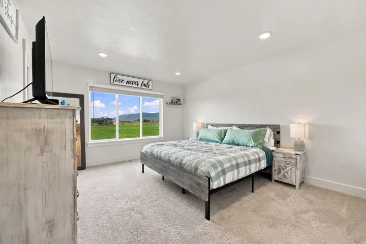 Light-colored carpeting, recessed lighting, and a large window with a scenic backdrop