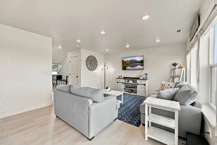 Recessed lighting, light wood-finish flooring, and multiple windows with blinds