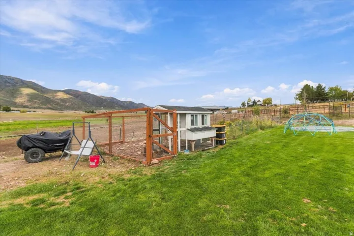 Expansive green lawn with a structural climbing dome, and a detached outbuilding with an enclosed run