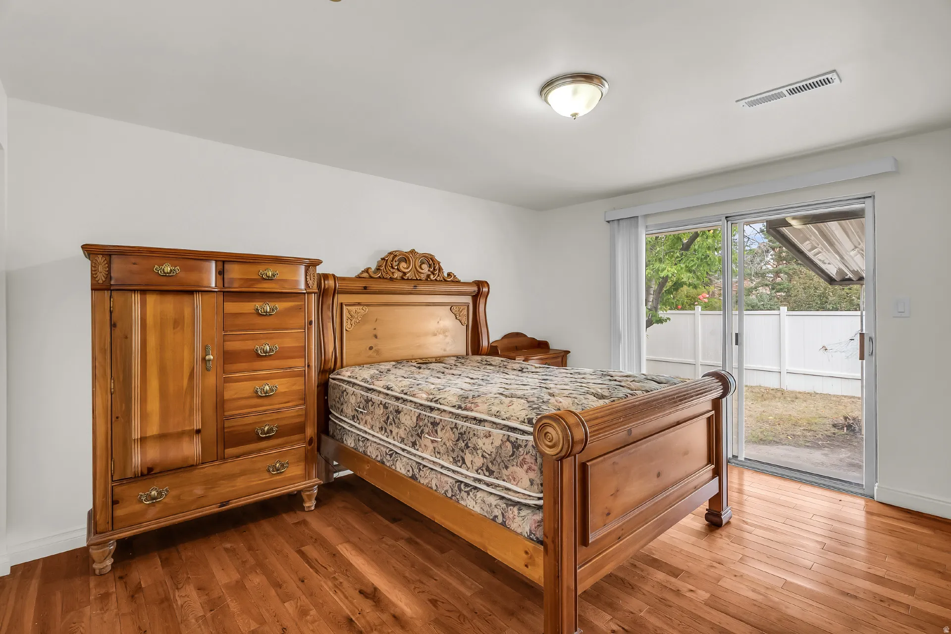 Wood-finish flooring, white walls, and a sliding glass door providing exterior access