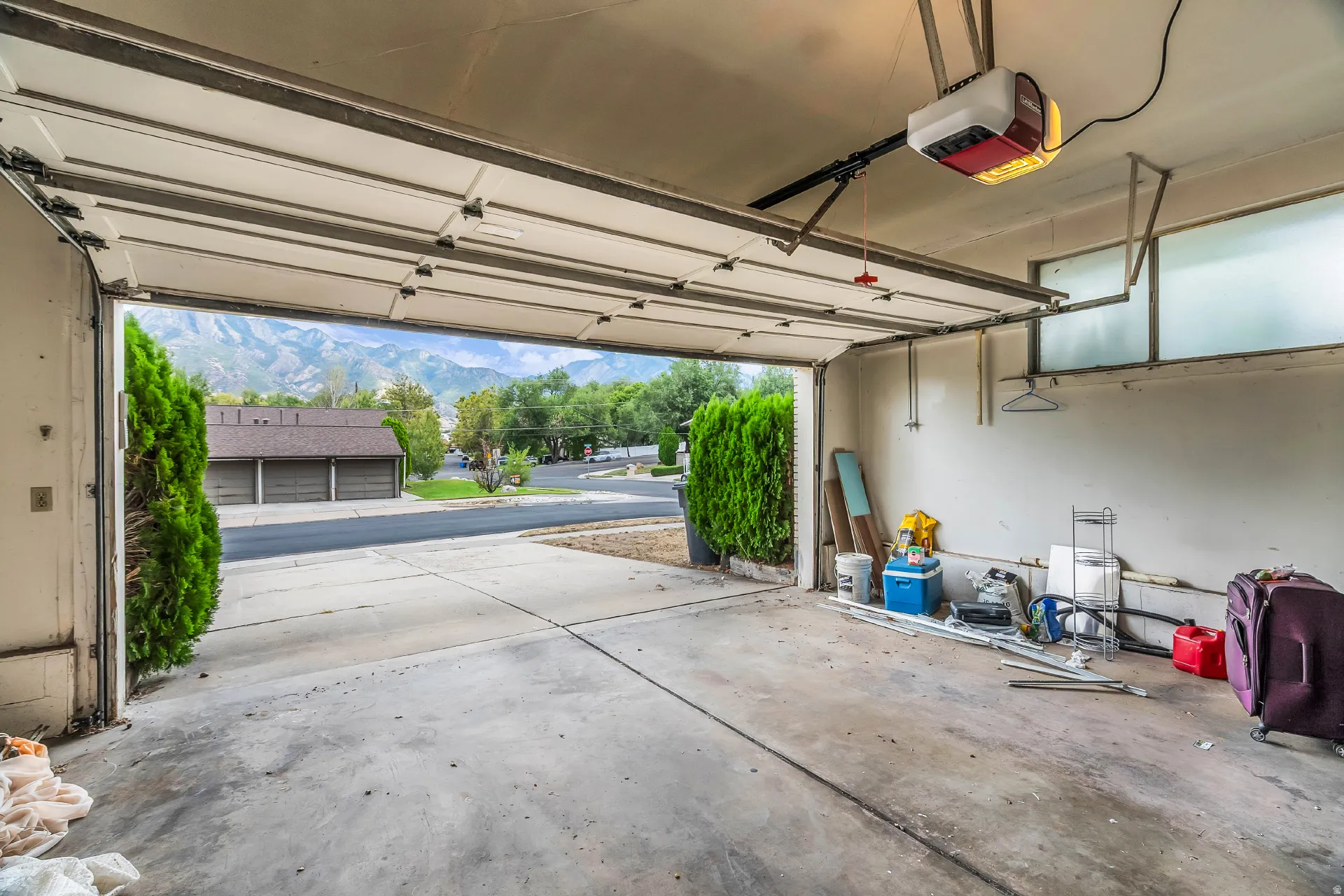 Attached garage featuring a concrete floor, automatic garage door opener, and upper transom windows