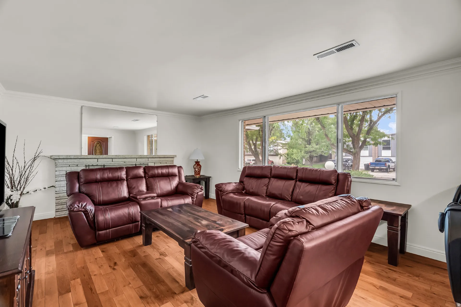 Wood-finish flooring, white painted walls, and crown molding